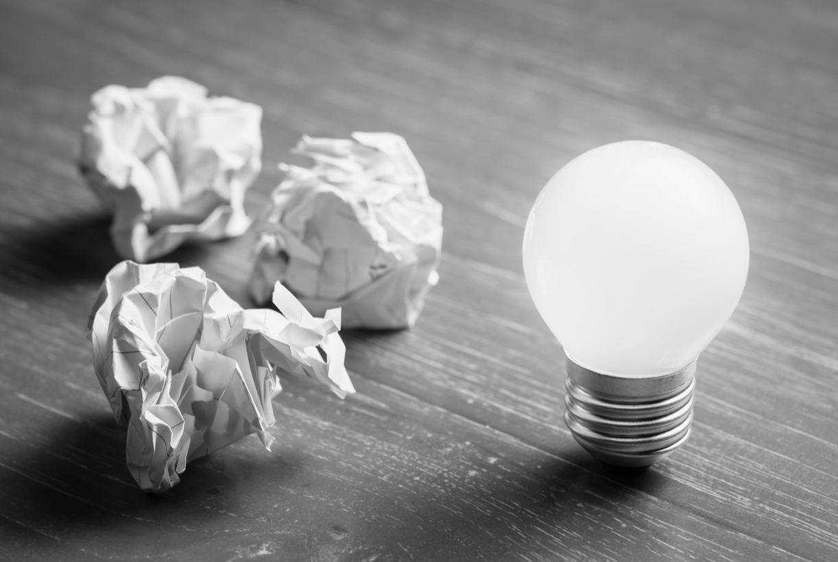 a lightbulb and crumples of paper on a table