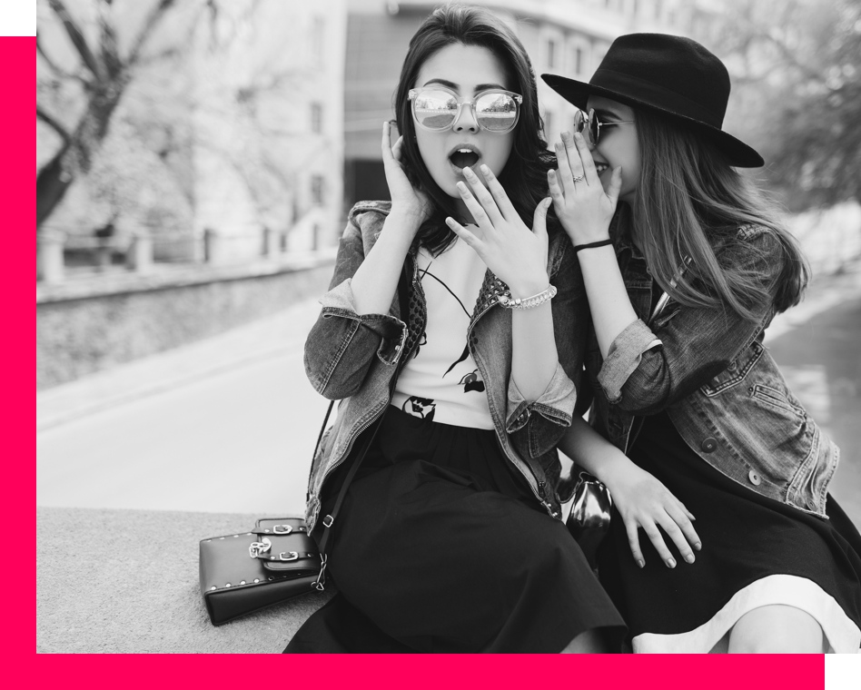 a girl whispering something surprising to her friend