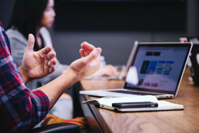 Meeting at a desk at an office, people gesturing