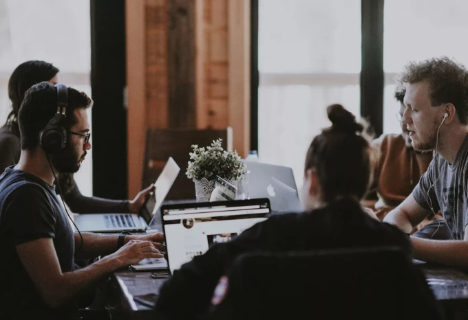 A handful of people at a workshop working together around a table