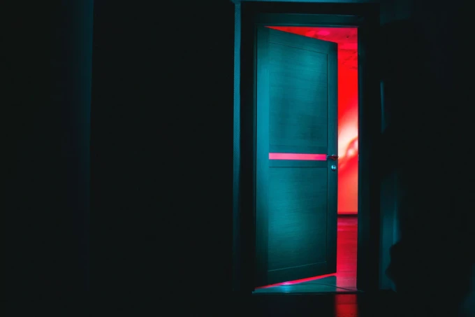 A door slightly open in a dark room