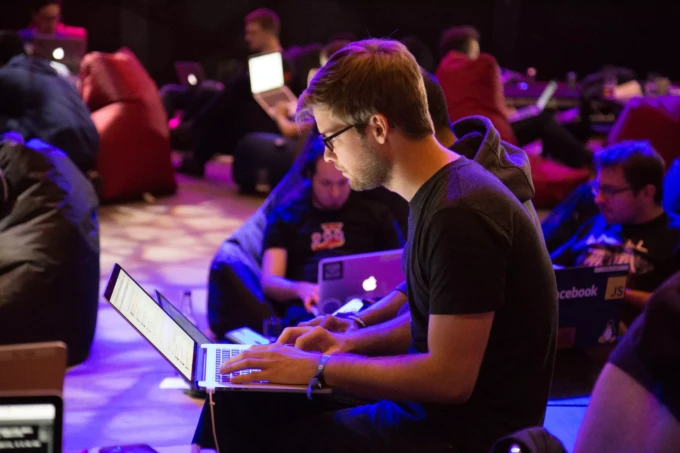 Man using laptop in front of brown chair photo