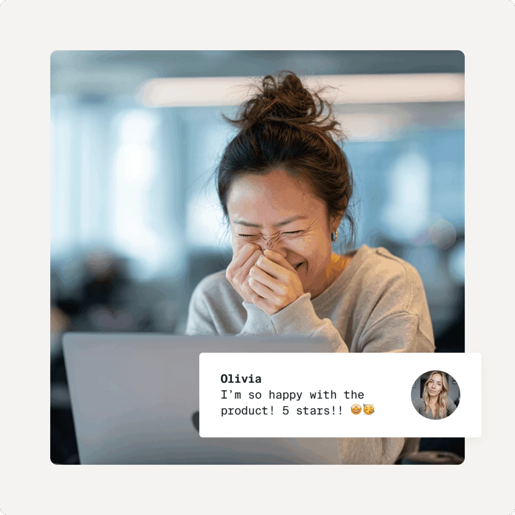 A super happy woman smiling to herself in front of an open Macbook laptop